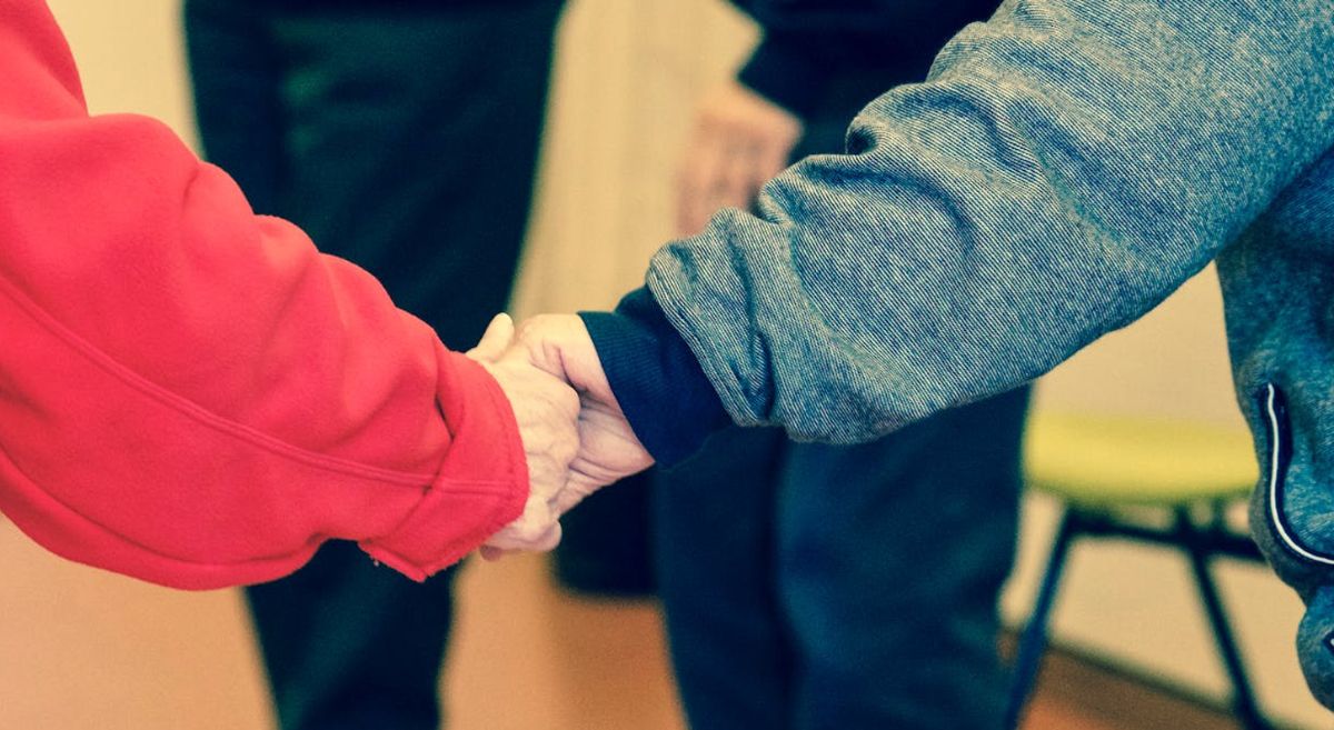 Carer holding a persons hand